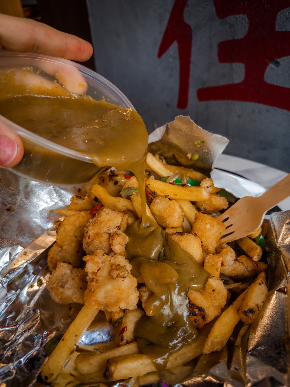 Curry sauce being poured over Chinese spice bag in Nottingham